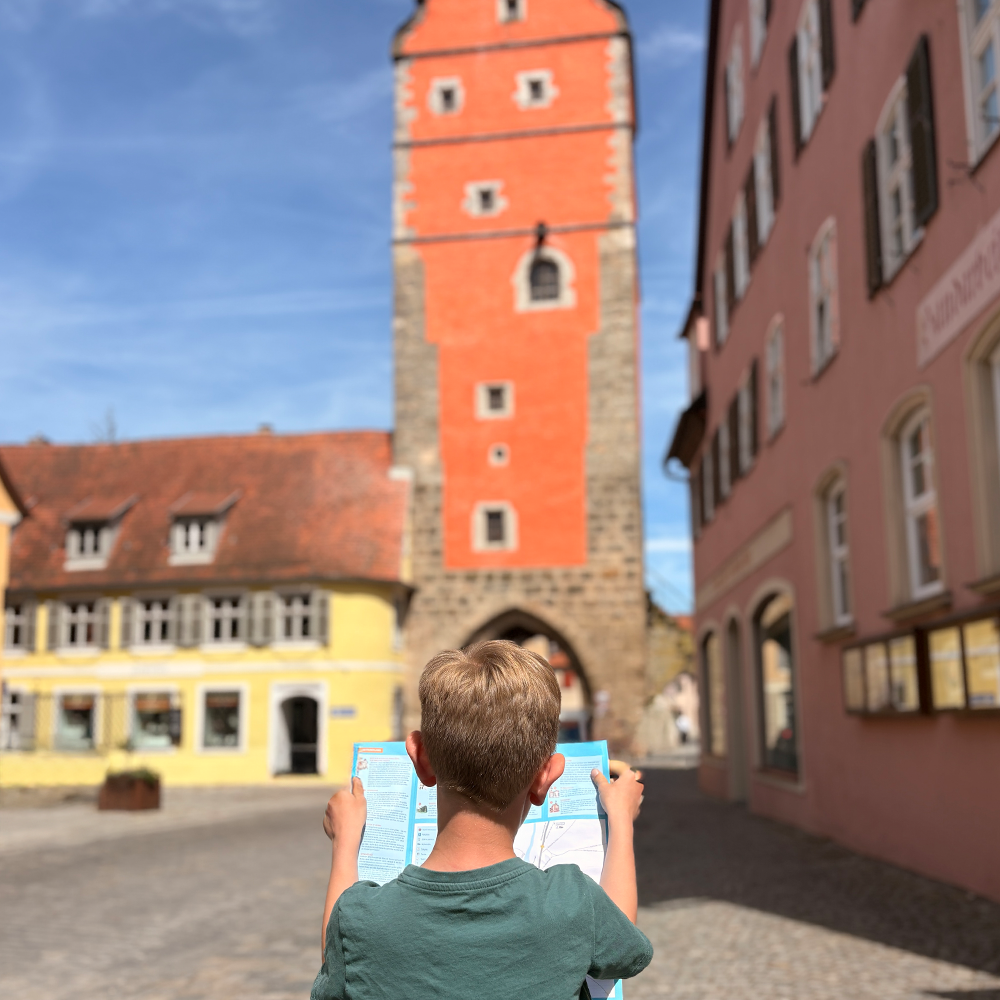 Spannende Infos im Kinderstadtf&uuml;hrer vor dem W&ouml;rnitztor lesen